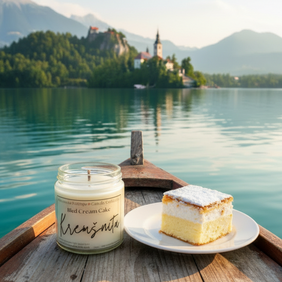 Candle and cake on a wooden boat with a scenic lake and mountains in the background