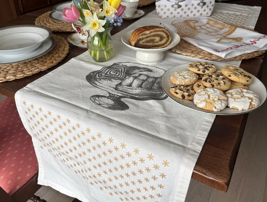 Handmade Queen Potica table runner from Slovenska Kuhinja, hand-printed organic cotton with festive Potica and red star design for Slovenian kitchen décor.
