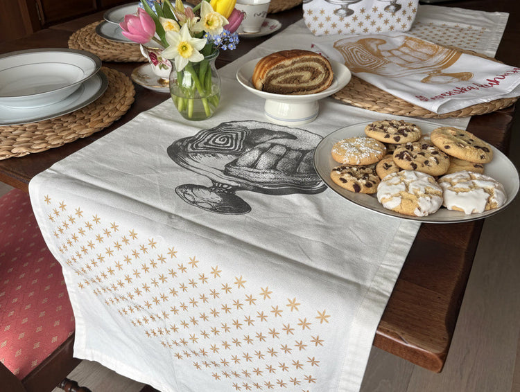 Handmade Queen Potica table runner from Slovenska Kuhinja, hand-printed organic cotton with festive Potica and red star design for Slovenian kitchen décor.
